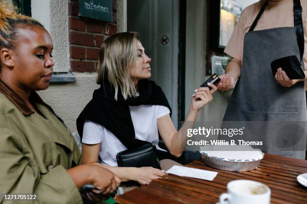 waitress taking a cashless payment - social distancing restaurant stock pictures, royalty-free photos & images