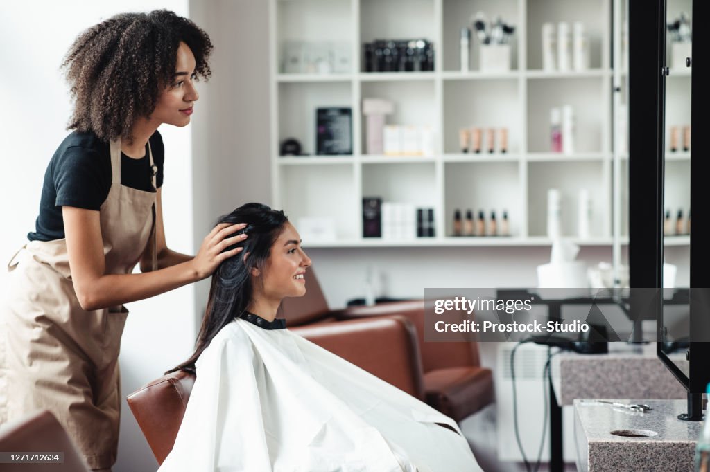 Young woman looking for changes, trying new hairstyle at beauty salon