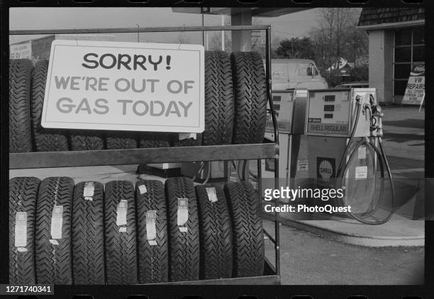 View of a sign that reads 'Sorry We're Out of Gas Today' on a rack of tires outside a Shell gas station, Washington DC, January 29, 1974.