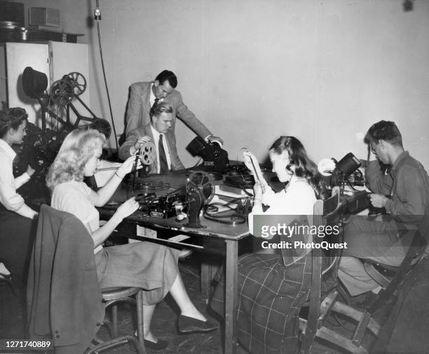 View of unidentified UCLA students as they cut and edit film during a class in the university's Theatre Arts program, Los Angeles, California, circa...
