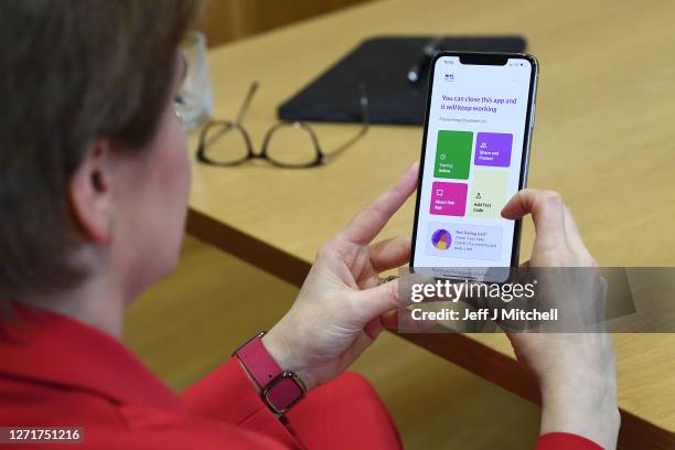 First Minister Nicola Sturgeon views the new Covid - 19 track and trace app on a phone at the Scottish Parliament on September 10, 2020 in Edinburgh,...