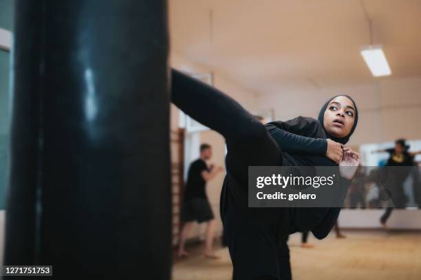 giovane donna sportiva con hijab praticare arti marziali - kick boxing foto e immagini stock