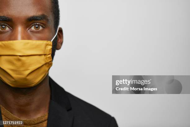 close-up african american male leader wearing handmade protective face mask. - yellow eyes stock pictures, royalty-free photos & images