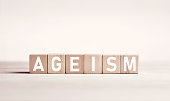 The word ageism on wooden blocks against white background. Age discrimination in business.