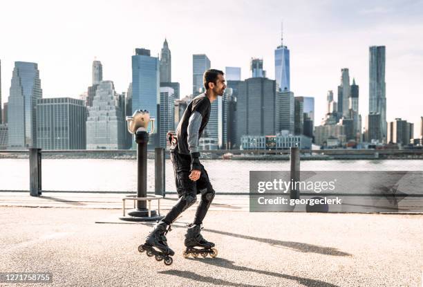 inline skater in front of the manhattan skyline - roller skating stock pictures, royalty-free photos & images