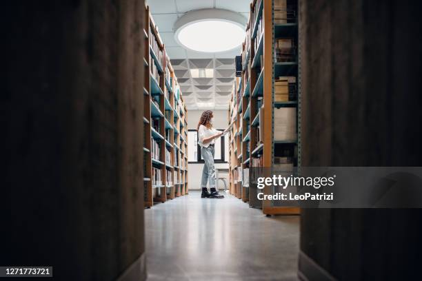 student choosing books on the bookshelf - library mask stock pictures, royalty-free photos & images