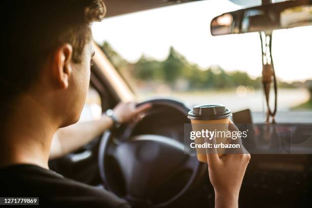 drinking coffee during car drive - sitting in car stock pictures, royalty-free photos & images
