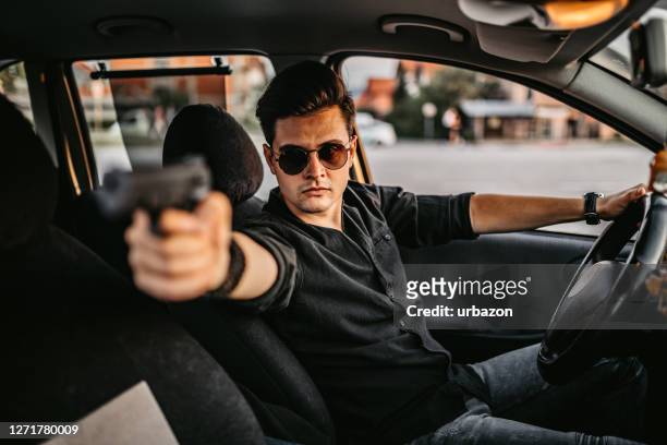 man driving a car and holding a gun - road rage stock pictures, royalty-free photos & images