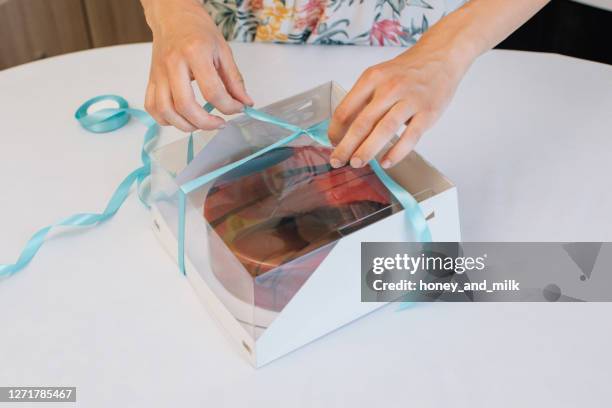 woman packing home made cake in a gift box - chocolate pack stock-fotos und bilder