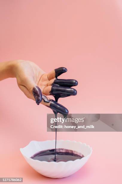 woman's hand covered in violet glaze - chocolate dipped stock pictures, royalty-free photos & images