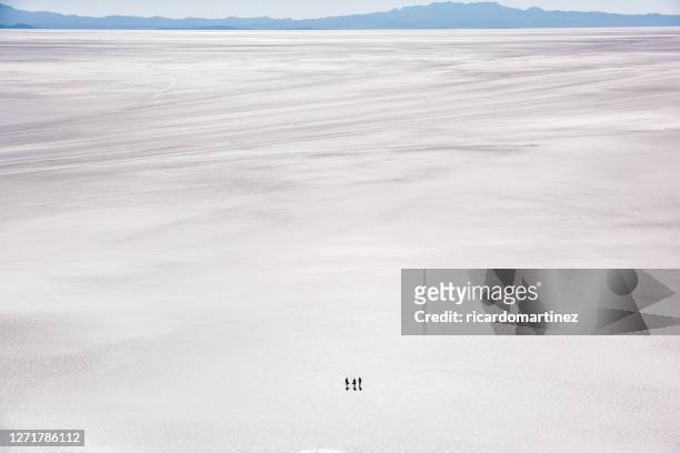 aerial view of three tourists walking across the uyuni salt flat, altiplano, bolivia - salt flat 個照片及圖片檔
