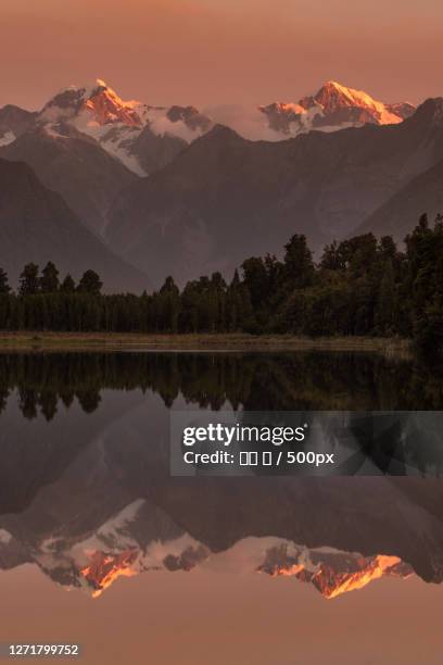 scenic view of lake by mountains against sky during sunset, amberley, new zealand - 夏 stock-fotos und bilder