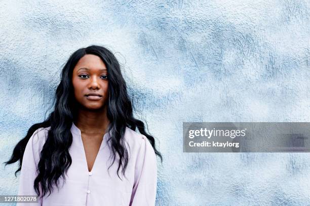 veel kopieerruimte omringt prachtige langharige tiener voor blauwe buitenmuur - african american teen stockfoto's en -beelden