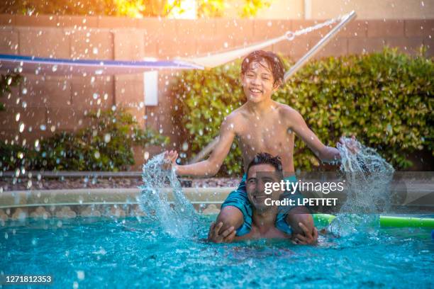 hinterhof pool spaß - family playing in backyard pool stock-fotos und bilder