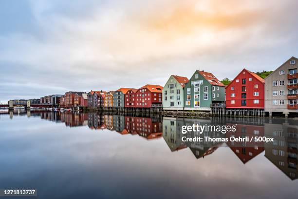 scenic view of lake by buildings against sky, trondheim, norway - trondheim stock-fotos und bilder