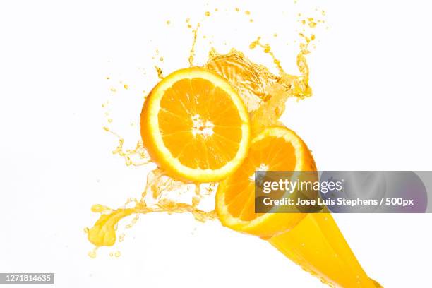 close-up of orange juice in glass against white background - orange juice glass white background stock pictures, royalty-free photos & images