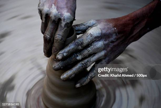 cropped hands of potter shaping earthenware on pottery wheel - potters wheel stock pictures, royalty-free photos & images