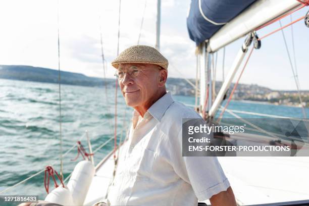 portrait of active senior sitting on a yacht deck in summer - sail boat deck stock pictures, royalty-free photos & images