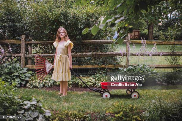 girl in the garden in a romantic vintage dress - red dress child stock-fotos und bilder
