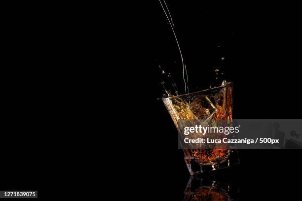close-up of splashing water against black background - rubbing alcohol stock-fotos und bilder