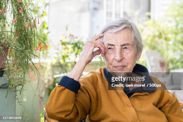 portrait of senior woman sitting on chair at home, zmir, turkey - ipek morel stock pictures, royalty-free photos & images