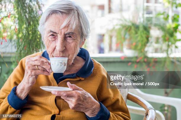senior woman drinking coffee in cafe, zmir, turkey - ipek morel stock pictures, royalty-free photos & images