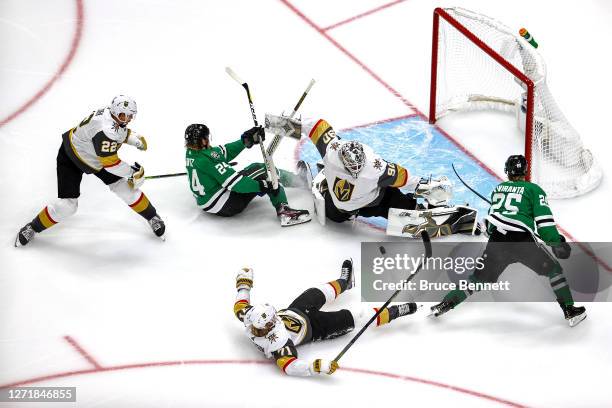 Joel Kiviranta of the Dallas Stars attempts a shot on Robin Lehner of the Vegas Golden Knights as Nick Holden checks Roope Hintz into the goal during...