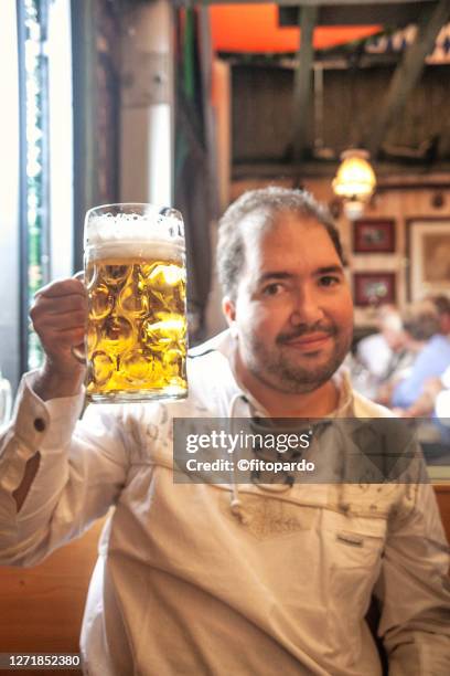 a man making a toast with a beer in the beer fest - beer jug stock pictures, royalty-free photos & images