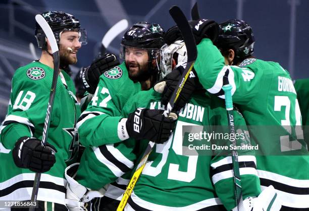 Goaltender Anton Khudobin of the Dallas Stars is congratulated by Jason Dickinson, Alexander Radulov and Denis Gurianov after their 3-2 overtime win...