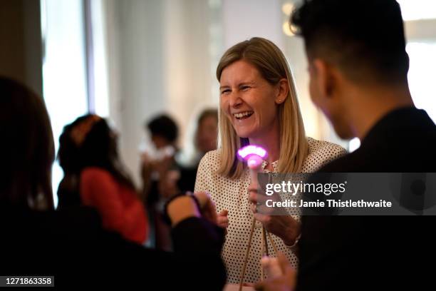 Charlotte Weatheall laughs at a neon mini fan during the "Henpire" podcast launch event at Langham Hotel on September 10, 2020 in London, England.