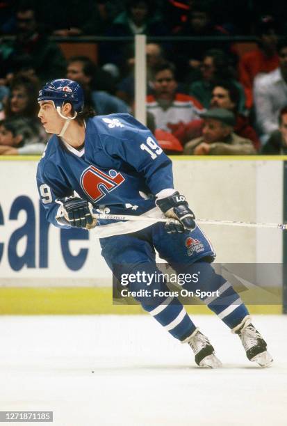 Joe Sakic of the Quebec Nordiques skates against New Jersey Devils during an NHL Hockey game circa 1990 at the Brendan Byrne Arena in East...