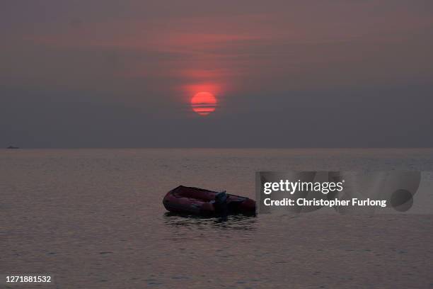 An empty migrant dinghy floats off the beach at St Margaret's Bay after the occupants landed from France on September 11, 2020 in Dover, England....