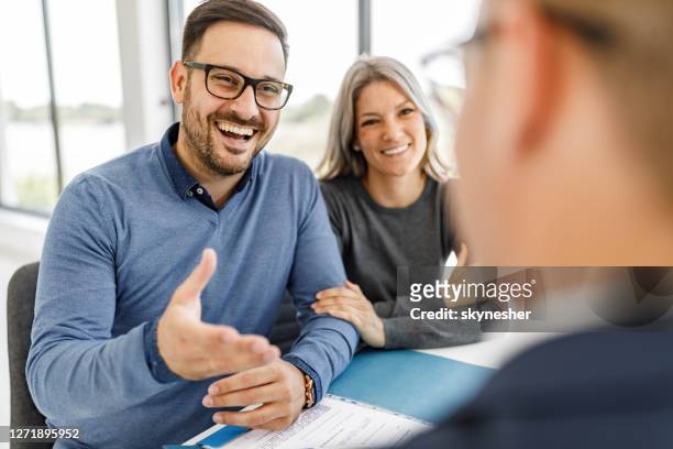 happy couple talking to their bank manager on a meeting in the office. - happy customer stock pictures, royalty-free photos & images