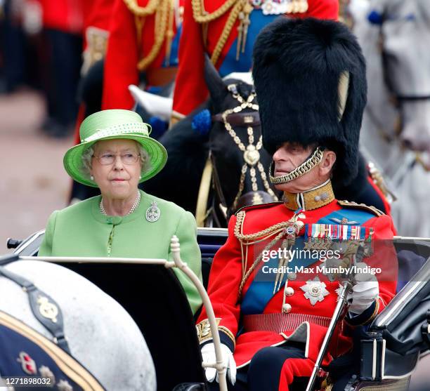 Queen Elizabeth II and Prince Philip, Duke of Edinburgh travel down The Mall in a horse drawn carriage during the annual Trooping the Colour Parade...