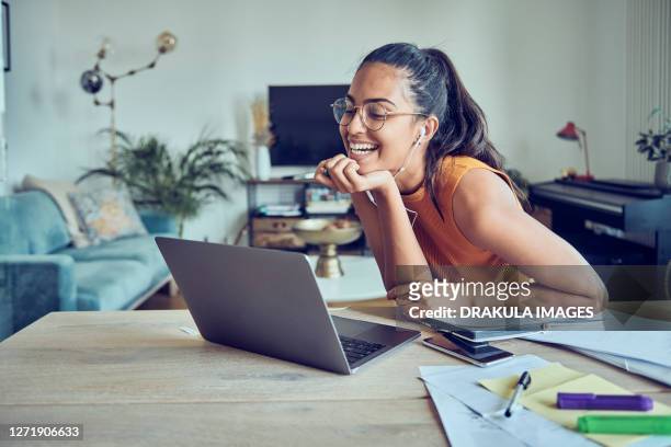 beautiful young woman working at home with laptop and documents - personalised communication stock-fotos und bilder