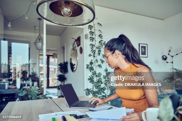 beautiful woman doing finances at home - banking document stock-fotos und bilder