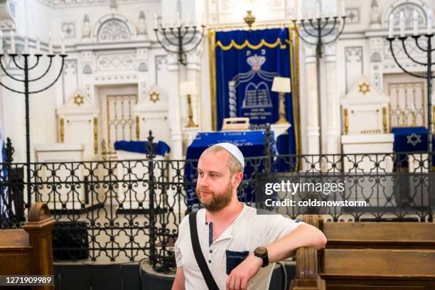 young jewish man wearing skull cap inside synagogue - jewish church stock pictures, royalty-free photos & images