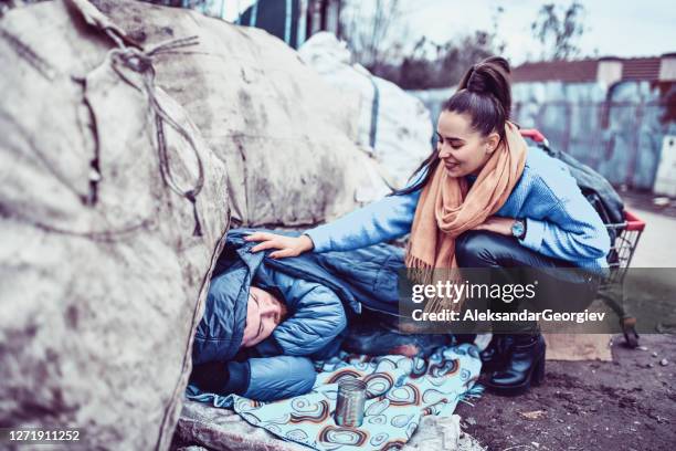 femme altruiste vérifiant l’état de santé de l’homme sans abri - beggar photos et images de collection