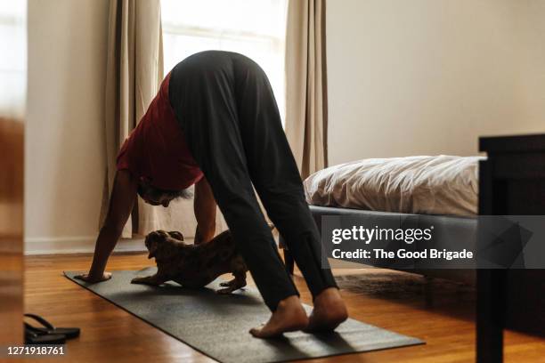 mature man practicing yoga in bedroom - man doing yoga in the morning stockfoto's en -beelden