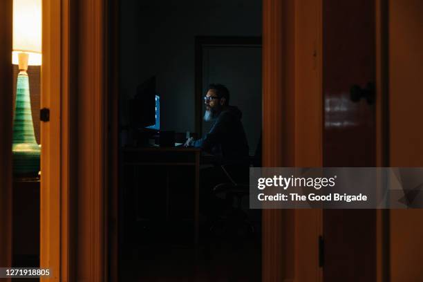 mature man working late on desktop computer - working overtime stock pictures, royalty-free photos & images