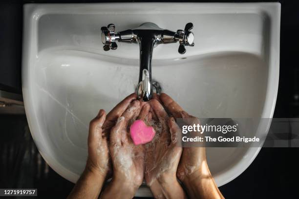 hands holding heart shaped soap - hygiene stockfoto's en -beelden