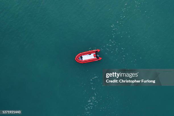 In this aerial image from a drone, an empty migrant dinghy floats off the beach at St Margaret's Bay after the occupants landed from France on...