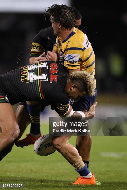 Clinton Gutherson of the Eels is tackled by Viliame Kikau of the Panthers and Stephen Crichton of the Panthers during the round 18 NRL match between...