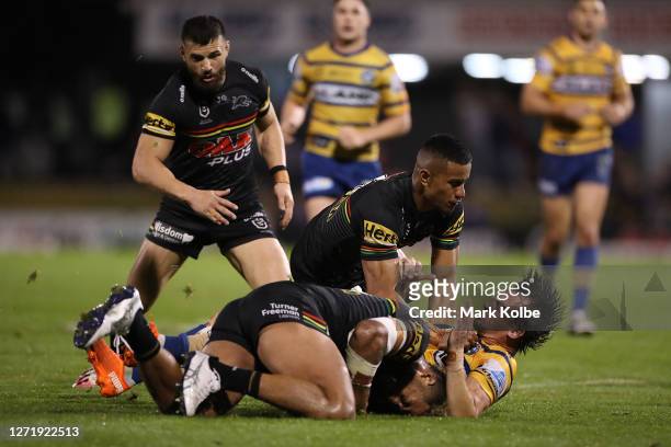 Clinton Gutherson of the Eels is tackled by Viliame Kikau of the Panthers and Stephen Crichton of the Panthers during the round 18 NRL match between...