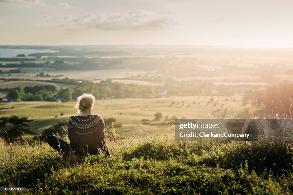 Portret van een rijpe vrouw die uit over het platteland kijkt.