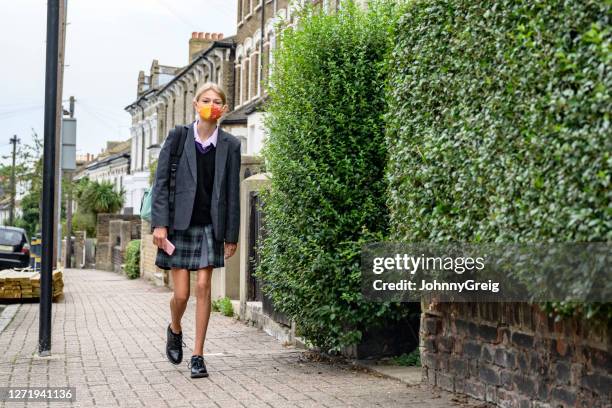 schoolgirl walking to school wearing face mask - 12 year old in skirt stock pictures, royalty-free photos & images