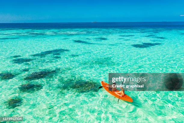 pareja joven remando en kayak de fondo de cristal en el océano tropical - kayak fotografías e imágenes de stock