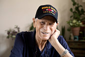 World War Two Veteran smiling head resting on hand looking at camera