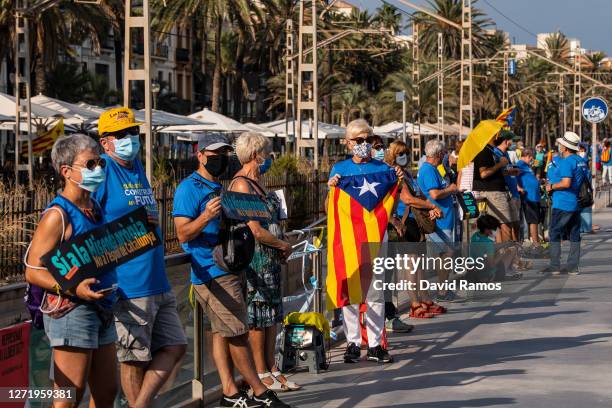 Demonstrators wearing protective face masks observe social distancing guidelines during a Catalan Pro-Independence demonstration on September 11,...