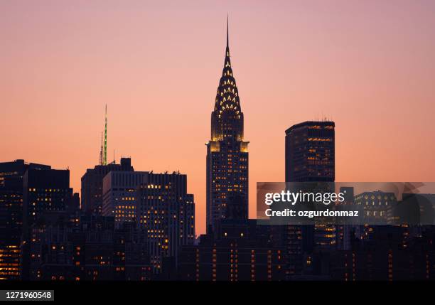 edificio chrysler iluminado al atardecer, new york city skyline - aguja chapitel fotografías e imágenes de stock